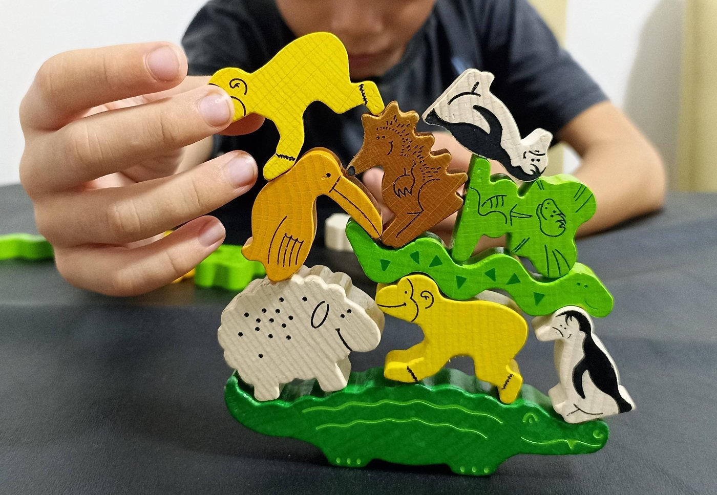Criança jogando com peças de um jogo de tabuleiro de madeira